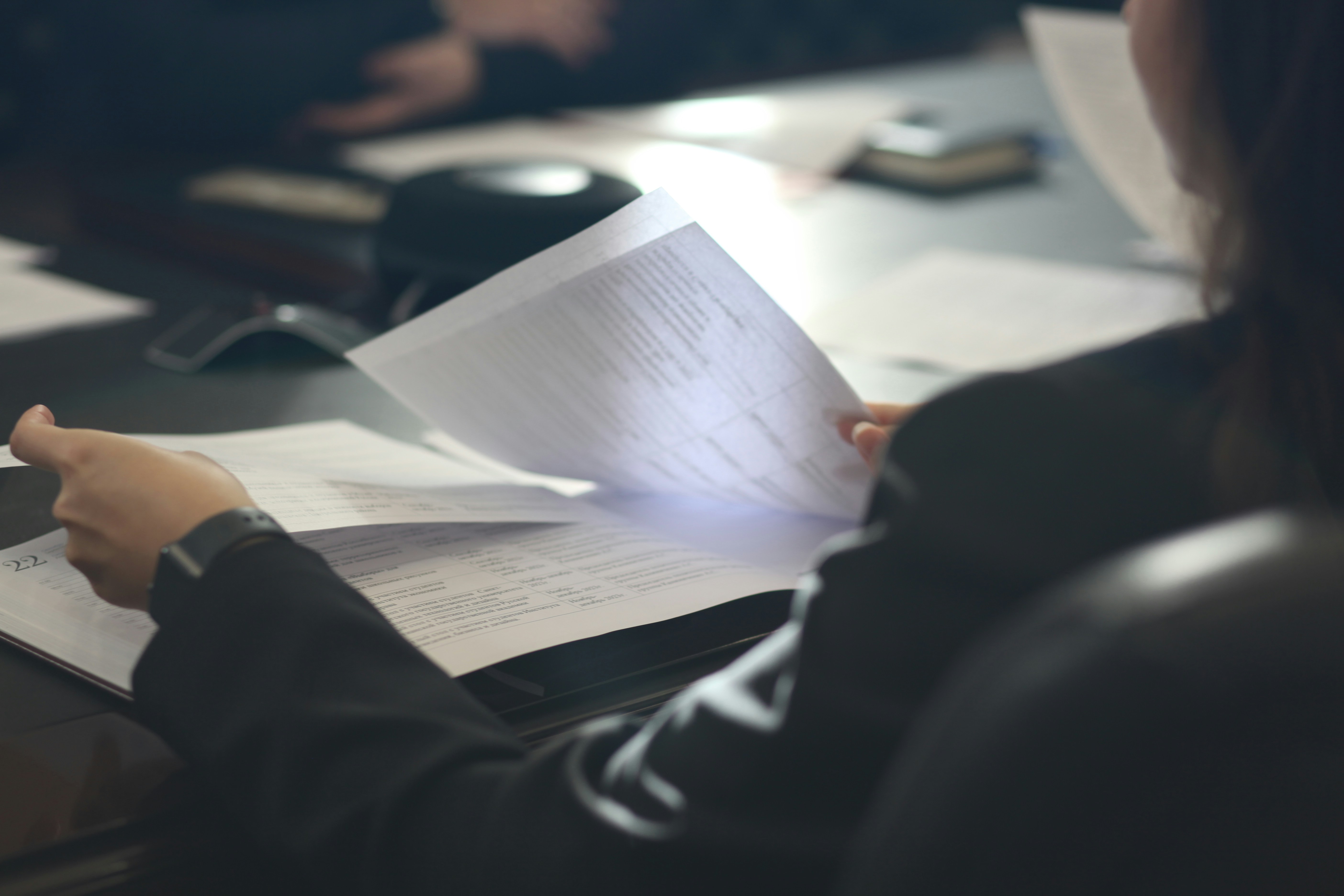 Person reviewing printed documents at a conference table