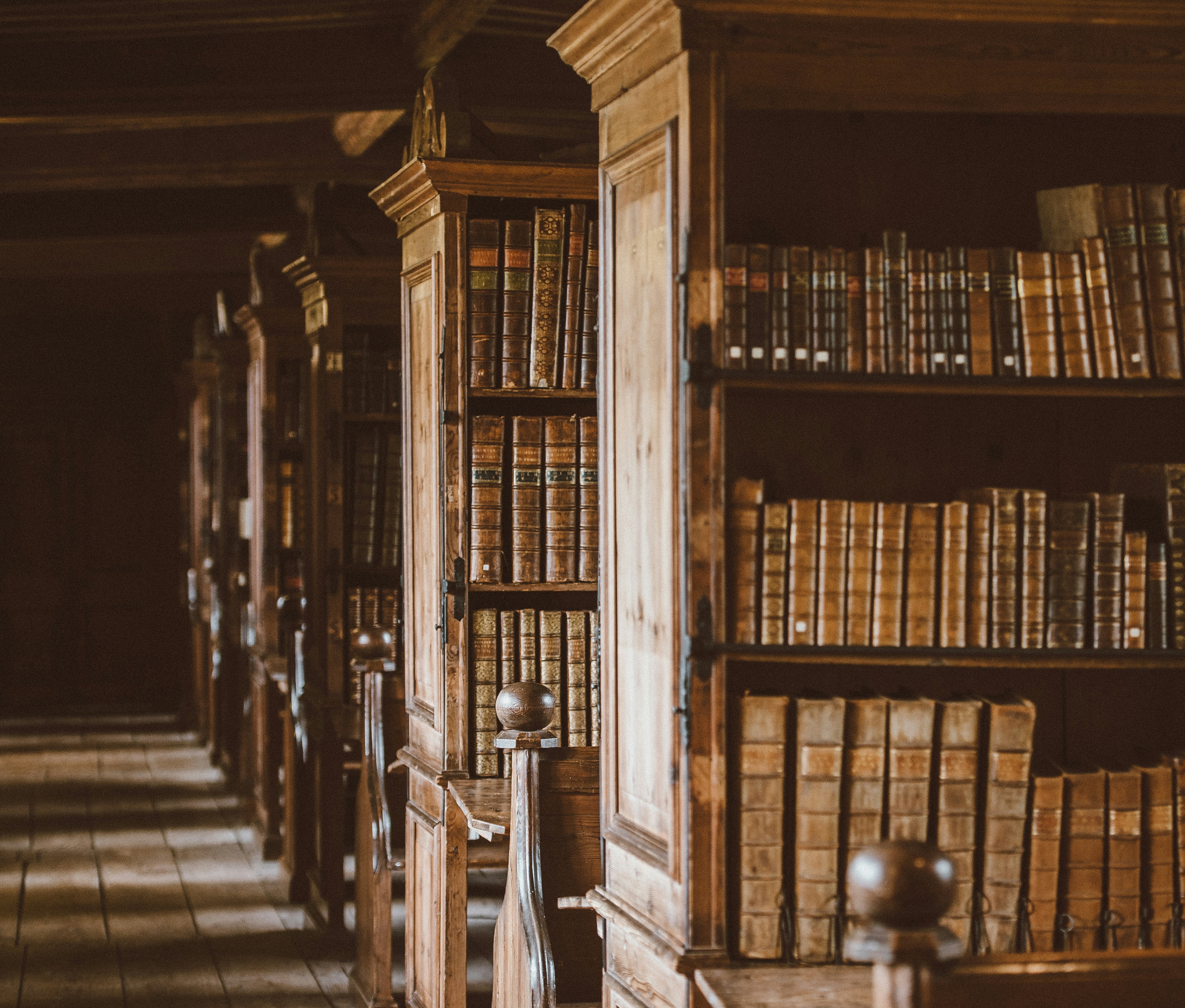 Historic library with wooden bookshelves and leather-bound volumes